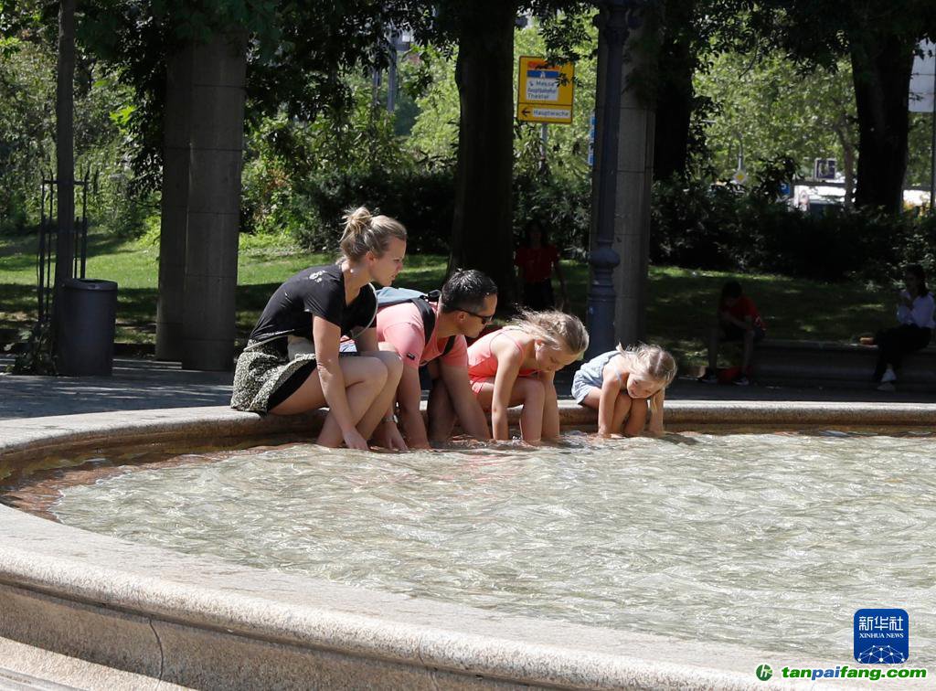 7月8日，人們在德國法蘭克福的一處噴泉玩水。近日，德國法蘭克福逐漸迎來暑熱天氣。新華社記者 張帆 攝